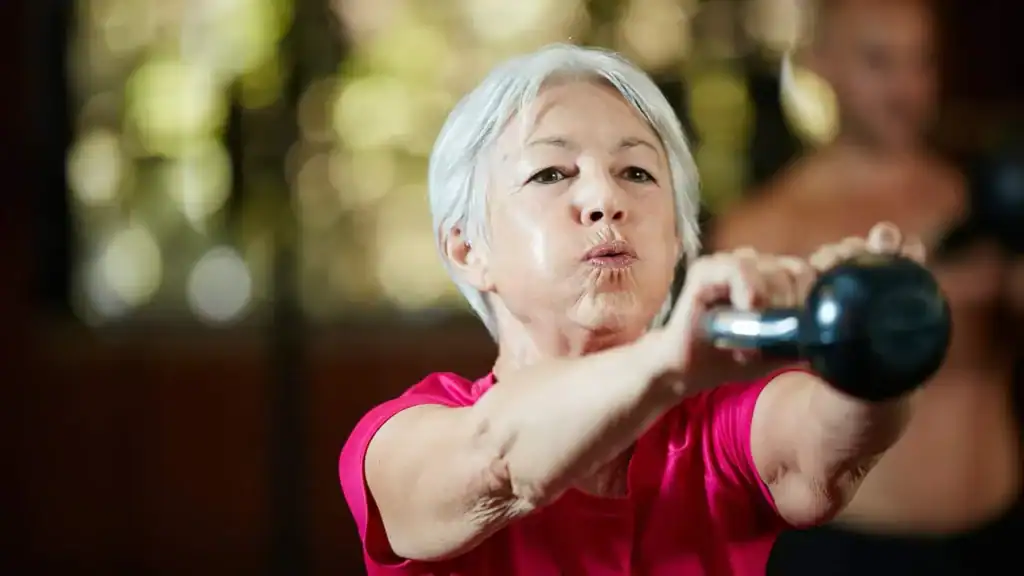 Older woman doing weight training Sunbury Common to help her strength and longevity 