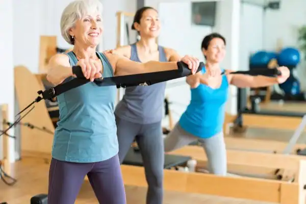 Toning Arms After 60: Empowering Womens Fitness Through Effective Weight Training 2 older woman doing weight training Sunbury Common and resistance in the gym to tone upper arms